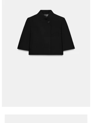 Kort svart kavaj med ståkrage - Stilren svart kavaj med kort, boxig passform och trekvartsärmar. Kavajen har en modern ståkrage, en knapp framtill och en diskret bröstficka. Materialet ser ut att vara slätt och vävt, vilket ger en clean look.