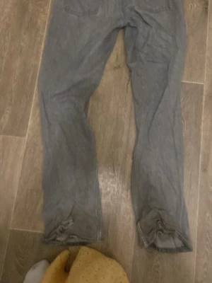 Grå raka jeans - Säljer ett par grå jeans med rak passform och klassisk femficksdesign. Jeansen har normal midja och är tillverkade i ett mjukt denimtyg som passar perfekt till en avslappnad stil.