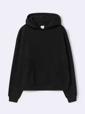 Svart oversized hoodie med huva - En svart oversized hoodie med huva och stor magficka. Hoodien har ribbade muddar vid ärmslut och nederkant, samt en klassisk avslappnad passform. Perfekt för en chill och stilren look. Materialet ser ut att vara mjuk bomullsblandning.