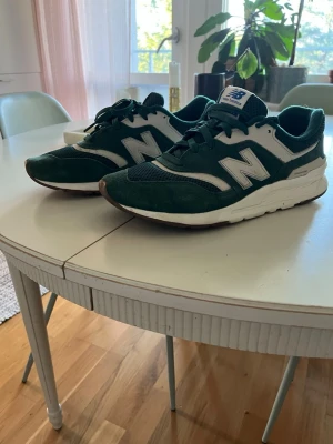 Gröna New Balance sneakers - Snygga gröna sneakers från New Balance med vita detaljer och den klassisk N-loggan på sidan.  Storlek 44, bra kvalitet knappast använda