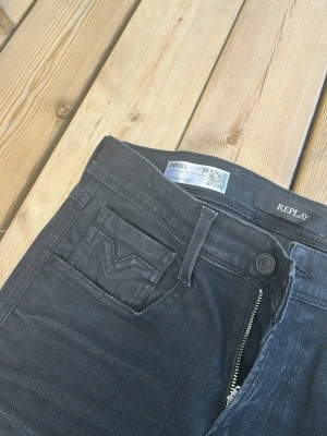 Svarta jeans från Replay, herr 30/32 - Snygga svarta jeans från Replay med klassisk femficksmodell och dragkedjegylf. Jeansen har en diskret tvättad look och är tillverkade i bomull med lite stretch för extra komfort. Perfekta för en avslappnad och trendig stil. Använda 1 gång. 