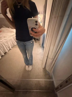 Ljusblå bootcut jeans - Säljer ett par ljusblå bootcut jeans med klassisk femficksdesign och låg midja. Jeansen har en snygg tvätt och sitter tajt upptill med utsvängda ben. Original pris 400