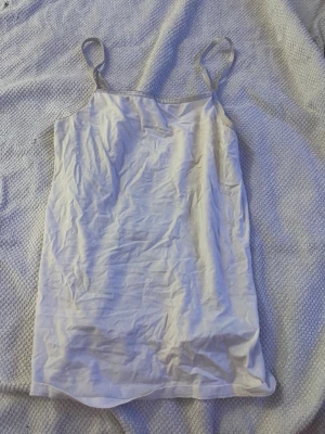 Beige linne med smala axelband H&M - Säljer ett basic beige linne från H&M med smala axelband. Tillverkat i mjuk ekologisk bomull som känns skön mot huden. Perfekt att styla lager på lager eller bära som det är under varma dagar.
