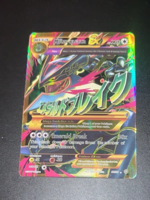 Pokémonkort Mega Rayquaza EX - Säljer ett Pokémonkort av typen Mega Rayquaza EX med holografisk yta och färgstark design. Kortet har attacken Emerald Break och är på engelska. Perfekt för samlare eller Pokémonfans som vill utöka sin samling.