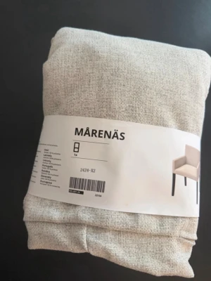 MÅRENÄS beige stolöverdrag - Säljer ett beige stolöverdrag från MÅRENÄS, perfekt för att ge din stol ett nytt utseende. Överdraget är gjort i ett slitstarkt tyg med struktur och passar till matstolar. Enkel att trä på och ta av.