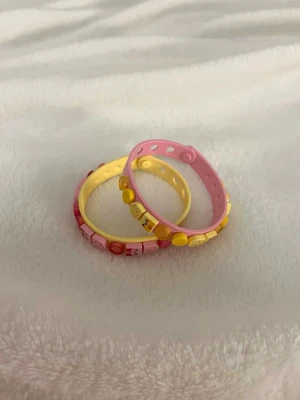 Två LEGO armband - Säljer två LEGO-armband, ett i rosa och ett i gult. Båda armbanden är dekorerade med små figurer💞