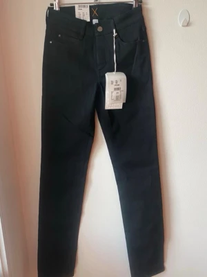 Svarta raka jeans med hög midja - Super fina och stretchiga jeans från Mac, med raka ben, storleken är W00, L32, vilket motsvarar XXXS enligt MAC, inköpta för 1 499:- 