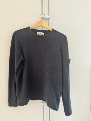 Stickad tröja från Stone Island - Stickad tröja från Stone Island med klassisk rund halsringning och ikonisk logotyp-patch på vänster ärm. Använt skick så lite missfärgad på några ställen men överlag bra, inga hål eller liknande. Upplever den lite mindre än normal medium från Stone Island.