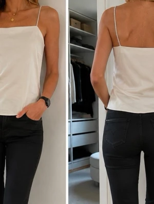 Offwhite topp med strassband H&M stl S Ny - Benvit Topp/fest från H&M i stl S med smala axelband som är dekorerade med strass. 100% viscose. Ny.  Skickar med posten mot porto, kan även hämtas vid Tekniska högskolan, Mörby C eller Täby C Stockholm. 