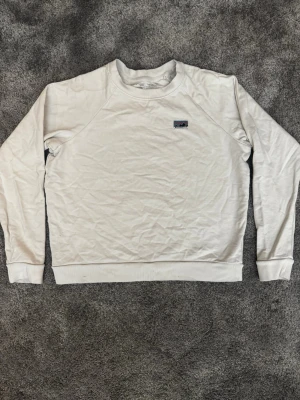 Vit sweatshirt från Patagonia - Säljer en stilren vit sweatshirt från Patagonia med klassisk logga på bröstet. Endas använd ett få tal gånger. 