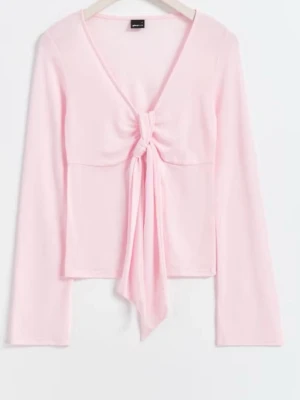 Ljusrosa topp med knyt och v-ringning - Supersöt ljusrosa topp med lång ärm och v-ringning. Toppen har en snygg knyt-detalj framtill som ger en unik look. Perfekt att styla med jeans eller kjol för en trendig outfit.