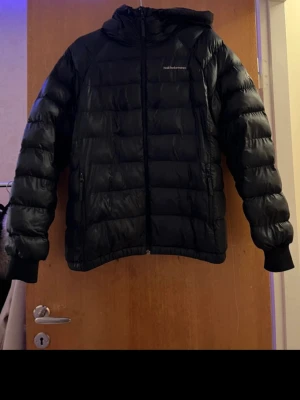Svart dunjacka Peak Performance L - Säljer en svart dunjacka från Peak Performance i storlek L. Jackan har huva, dragkedja framtill och två sidofickor med dragkedja. Klassisk puffer-modell som är perfekt för kalla vinterdagar. Diskret logga på bröstet och elastiska muddar vid ärmsluten. Samt två småa hål som man knappt tänker på (se bild 3), pris kan diskuteras vid snabb affär! 🩷🤗