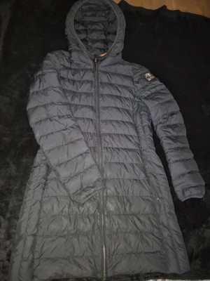 Parajumpers Irene dam - Håll dig varm och stilfull med Parajumpers Irene Jacket, en lyxig dunjacka skapad för ultimat komfort och skydd. Designad med högkvalitativ matt polyestertaft och en vattenavvisande finish, är denna jacka perfekt för kallare månader. Viktiga egenskaper: Svart | Matt Polyestertaft | Vattenavvisande | Dragskojusterbar huva | Ventilation under armarna | Fyra fickor med dragkedja | Klassisk Parajumpers logopatch på ärmen | Mått och passform: Normal passform | Material och skötsel: 90% Ankdun | 10% F