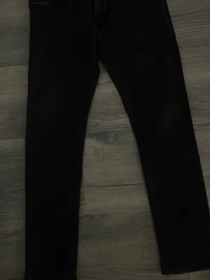 Svarta skinny jeans - Säljer ett par svarta skinny jeans med klassisk femficksmodell och smal passform. Jeansen har normal midja och raka ben. Materialet är stretchigt vilket gör dem bekväma och lätta att röra sig i. Perfekta till en avslappnad stil. 34 midjan 32 längd 