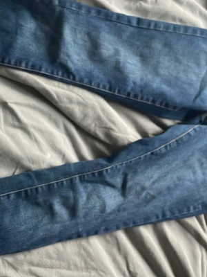 Blå jeans från ONLY - Snygga blå jeans från ONLY med klassisk tvätt och raka ben. Jeansen har kontrastsömmar och är tillverkade i ett mjukt denimtyg som sitter skönt. Perfekta för dig som vill ha en enkel och stilren look.