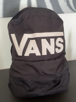 Svart ryggsäck från Vans - säljer en ryggsäck ifrån vans perfekt nu till skolstarten tyvärr 2 fläckar på baksidan av väskan men går särkert att tvätta bort 