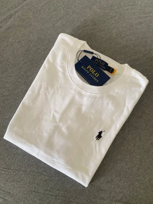 Ralph Lauren T-shirt  - Inga skador eller hål Klassisk vit t-shirt från Polo Ralph Lauren med rund halsringning och den ikoniska lilla broderade loggan på bröstet. Tillverkad i mjuk bomull för en skön och stilren look. Perfekt basplagg till garderoben. Pris kan diskuteras vid snabb affär 