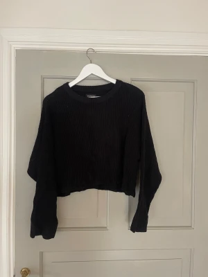 Svart cropped stickad tröja Even&Odd - Säljer en svart cropped stickad tröja från Even&Odd. Tröjan har rund halsringning, långa ärmar och är ribbstickad för en snygg och enkel look. Perfekt till höst och vinter för en trendig och avslappnad stil.