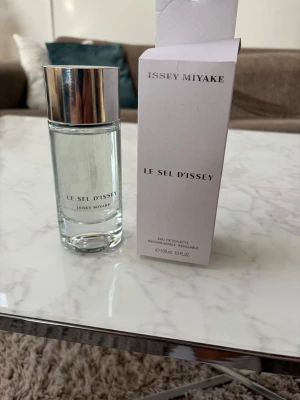 Le Sel d'Issey parfym 100 ml knappt använt. - Le Sel d'Issey från Issey Miyake är en elegant parfym i en stilren, genomskinlig glasflaska med silverfärgat lock. Flaskan rymmer 100 ml och har en minimalistisk design med svart text. Kommer med originalkartong. Knappt använt. Luktar otroligt gott