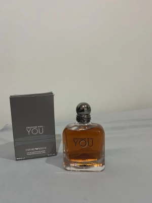 Stronger With You parfym - Stronger With You från Emporio Armani är en parfym med en stilren, fyrkantig glasflaska och silverfärgad rund kork. Doften har en varm bärnstensfärgad vätska och levereras med originalförpackning i grått. Perfekt för dig som gillar eleganta och moderna dofter.