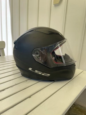 Mopedhjälm  - Välanvänd men fullt funktionell mattsvart mopedhjälm från LS2, modell: LS2 rapid. Ny tvättade avtagbara delar från insidan (se sista bilden). Storlek M, 57-58 cm. Märkbart med märken men inga större märken. Knappt några repor på hjälmen. 