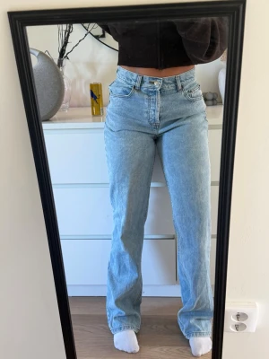 Ljusblå jeans - Ett par ljusblå jeans med raka ben i storlek 28/32. Jeansen har en avslappnad passform och är tillverkade i denim. Perfekta för en trendig och bekväm look.