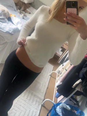 Vit stickad tröja med pärldetaljer - Säljer en mjuk och fluffig vit stickad tröja med rund halsringning och långa ärmar. Ärmarna har fina pärldetaljer som ger en extra touch. Tröjan har en figurnära passform och är perfekt för kyligare dagar.