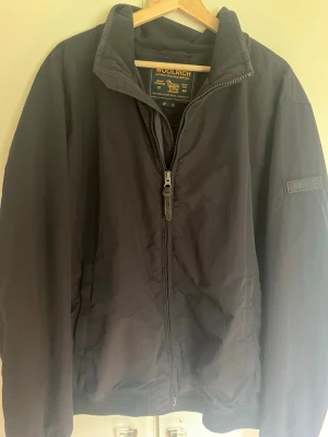 Woolrich jacka - Säljer en stilren och tidlös Woolrich John Rich & Bros-jacka i svart. Jackan är i storlek 3XL, men passar även mindre storlekar om man vill ha en oversized/baggy fit. Jag brukar ha S–M och den sitter snyggt oversized på mig. Sitter väldigt snyggt till golfen.  Nypris ca 6000
