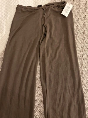 Taupe loungebyxor My Chill Pants XS - Mysiga loungebyxor i taupe från My Chill Pants. Byxorna har en avslappnad passform med resår i midjan och raka ben. Perfekta för hemmakvällar eller när du vill chilla. Mjukt och skönt material som känns bekvämt mot huden.