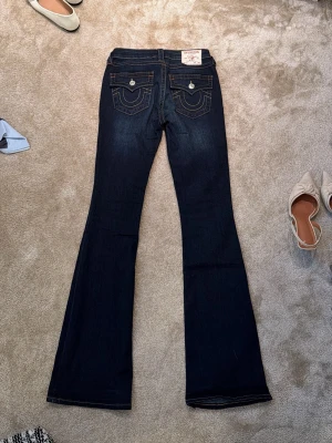 True Religion mörkblå bootcut jeans - Säljer ett par mörkblå bootcut jeans från True Religion! I storlek w27