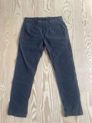 Mörkblå Chinos - Säljer mina mörkblåa chinos från det italienska märket Doppelgänger som jag nästan aldrig använt. Byxorna är i chinos-storlek  48 och är i ett väldigt skönt, stretchigt och behagande material vilket gör att de går att spela golf i liksom ha skjorta och kavaj till!