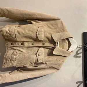 Hollies beige mocka jacka  - En hollies jacka i mocka, använd men i väldigt gott skick. Jacka i storlek: S  | frakt inräknat i priset 