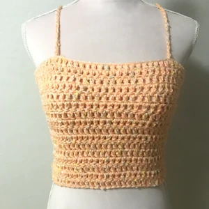 Virkat linne - Persikofärgat virkat linne gjort av speckle garn med bland annat vitt i sig. Passar många sorlekar då den har snörning och knytning i ryggen