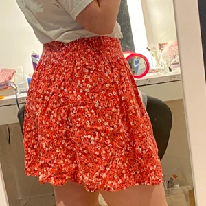 Röd blommig kjol - Supersöt kjol. Säljes för att rött inte riktigt är min färg:) Använd några gånger så i väldigt fint skick fortfarande<3