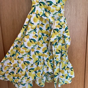 Gina tricot klänning - Citronmönstrad klänning från Gina tricot i storlek 42. V-ringad med smala band och trendig kjol. Lite svårt att visa hur den ser ut, så kontakta mig om fler bilder. Den är använd ca 3 gånger och i princip som ny. Köparen står för frakt och returneras ej💛