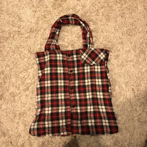 Tote bag gjord av flanellskjorta  - En ganska lagom stor tygkasse. Stor nog var att bära en IPad. Korta remmar. Sydd på maskin