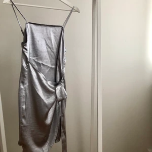 Silverklänning från NAKD - Supercool klänning från Kristin Sundberg for NAKD i silvrigt Metallica-tyg. Strl 36. Använd endast en gång. Steamas innan jag skickar den!
