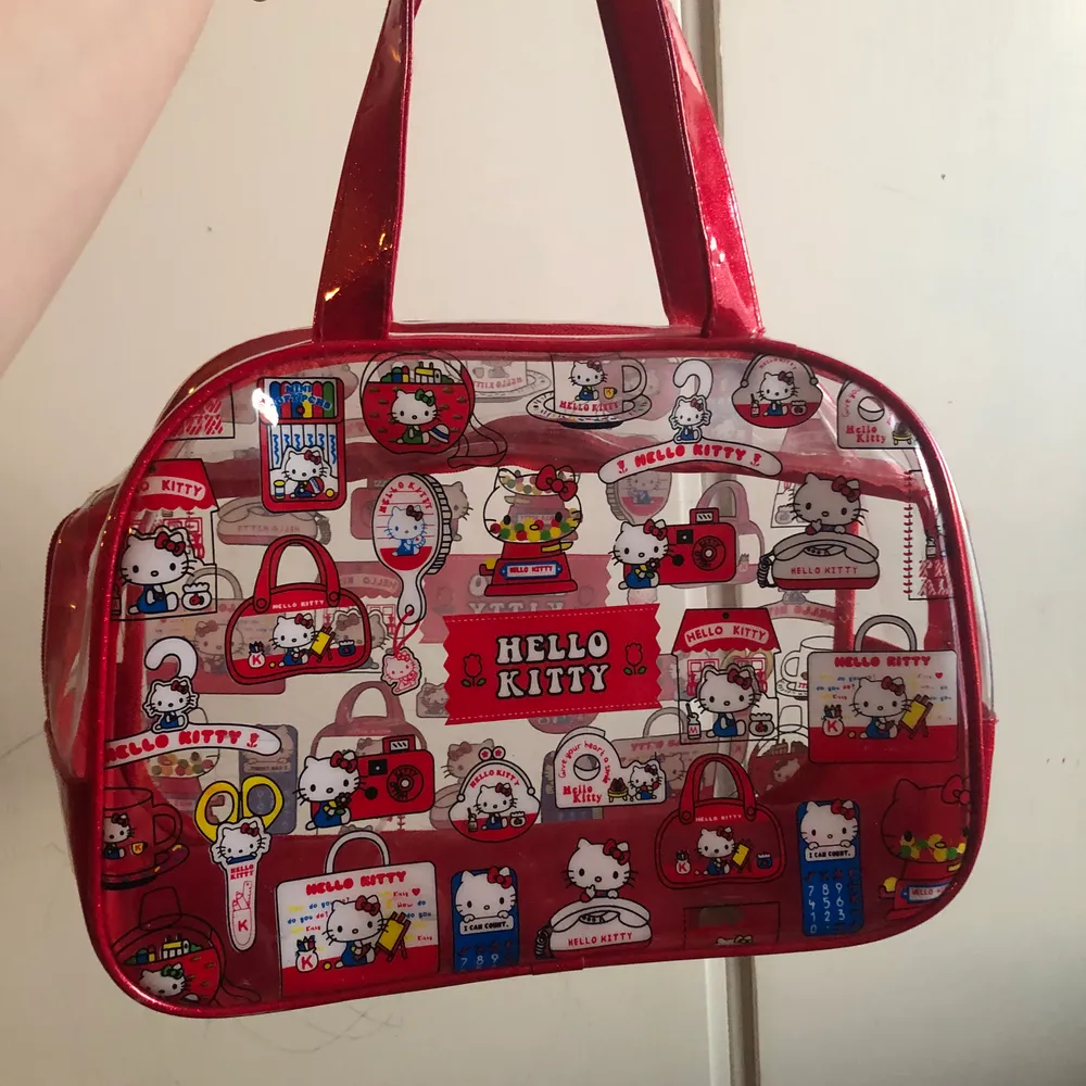 En röd och genomskinlig hello kitty väska från kawaii shop!!! Använt ändats ett par få gånger!. Väskor.