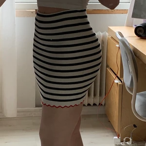 Svartvit kjol - Svartvit randig kjol från Zara. Ribbad och har en röd volangkant. Använd en gång. Köpare står för frakt.