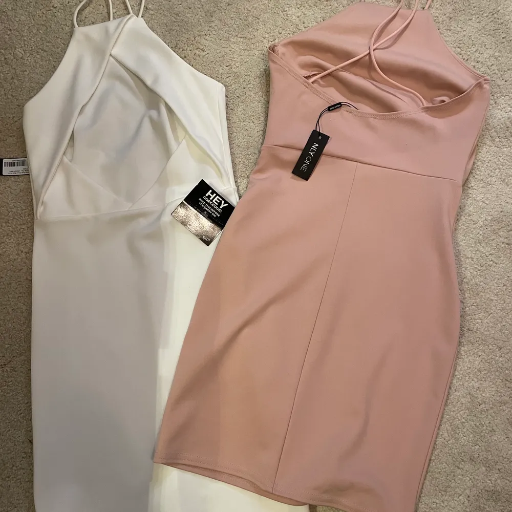 Två jättefina oanvända halterneck/fodralklänningar från NELLY.com. Lappar finns kvar på båda klänningar. Strl XS/34. 50kr styck eller båda för 80kr. (OBS! Den vita är såld). Klänningar.