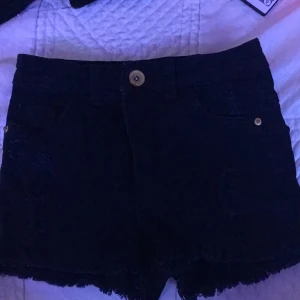 Shorts. Stl. 140 - Svarta shorts med lite hål. Från Kappahl.