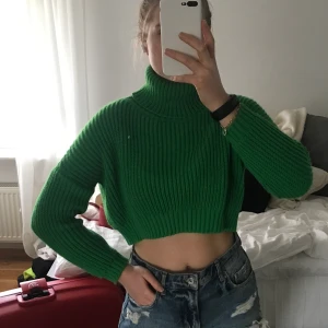 Grön stickad croppad tröja - Superhärlig croppad tröja från ØST London. Inköpt i Köpenhamn 2020 (Rude store) för ≈650kr. Aldrig använd då jag tycker den är för liten på mig (är 180 cm)