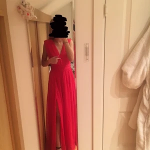 Röd balklänning - Säljer en röda balklänning, sharp V-Neck grown från Nelly.com, aldrig använd utan endast provad, är i storlek 34 (köparen betalar frakten)