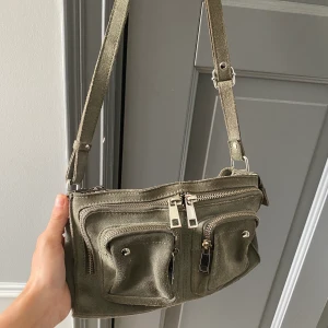 Nunoo väska - Säljer min väldigt varsamt använda nunoo väska i en superfin olivgrön färg med silvriga detaljer.🥰❤️ Väskan är i bra skick och har inga fläckar osv.