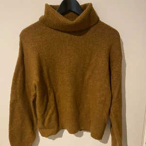 Brun stickad teöja - En jättefin brun stickad tröja från HM. Hög krage och perfekt lång i armana. Passar perfekt till alla tillfällen. Fin höstbrun färg.