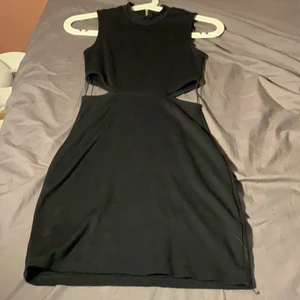 Klänning i storlek xs  - En klänning som är tajt på och med två hål på varje sida av magen och en dragkedja i ryggen skönt material och inga hål eller skador 