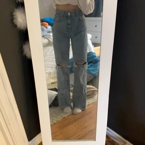 Straight leg jeans - Säljer mina blåa straigh leg jeans från Zara! Slits/hål på båda knäna. Sitter jätte fint i midjan. Jag är 167cm lång och byxorna går precis under hälarna. Slits i slutet av byxorna. Använt 2 gånger. Köpte för 499kr säljer för 200kr +frakt 