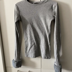 y2k tröja - Grå ribbad långärmad tröja från Zara trafaluc med päls / fluff längst ner på ärmarna. Superfin men har tyvärr alldeles överfull garderob!!   📬 Frakt 57kr 📬 Följ tryggt paketet hela vägen i postnordappen då jag skickar med Skicka Lätt  Kolla in mina andra annonser jag samfraktar gärna 😊