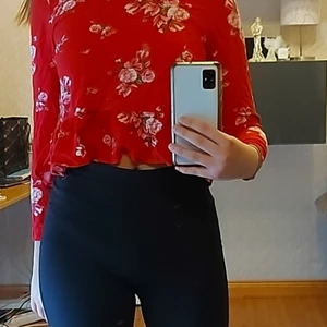 Röd blommig tröja - Röd tröja med fina blommor över hela tröjan, storlek 34 som motsvarar XS/XXS, måste strykas, bra skick, skriv meddelande vid intresse, pris kan diskuteras