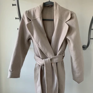 Ullkappa från H&M  - Kappa i ullmix ifrån H&M. Vet inte storleken då lappen är borta men skulle gissa på att det är S. Kappan är i använt skick men fortfarande väldigt fin.